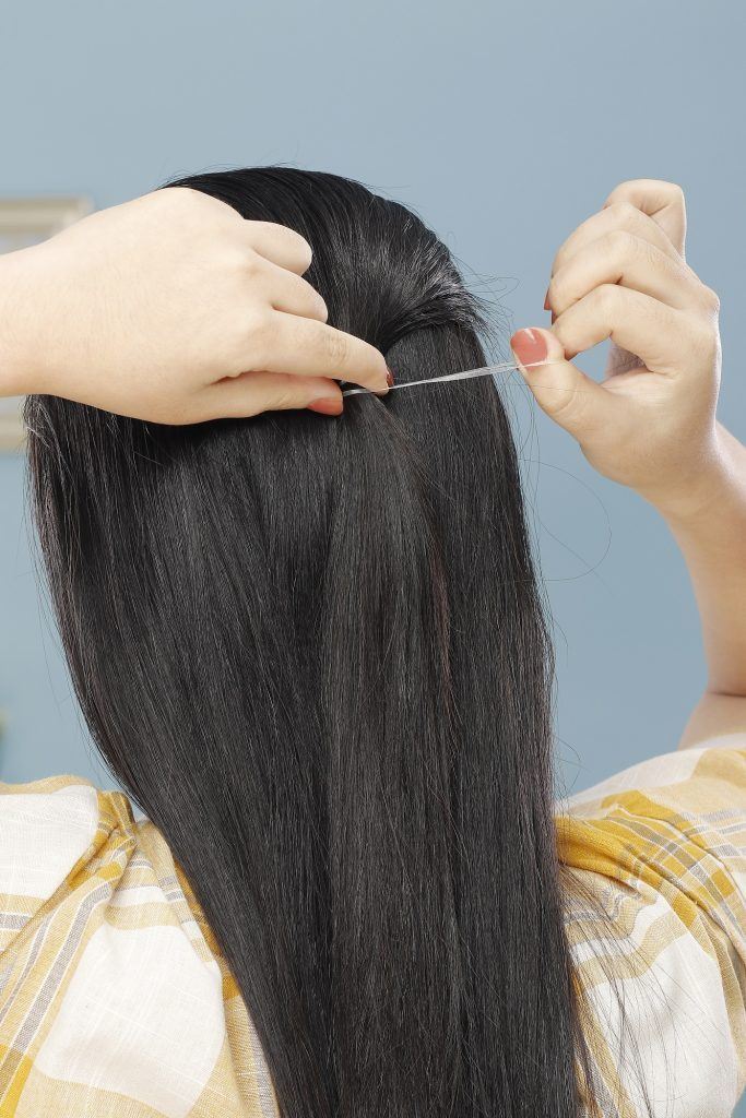 wanita asia berambut hitam panjang sedang mengikat rambut