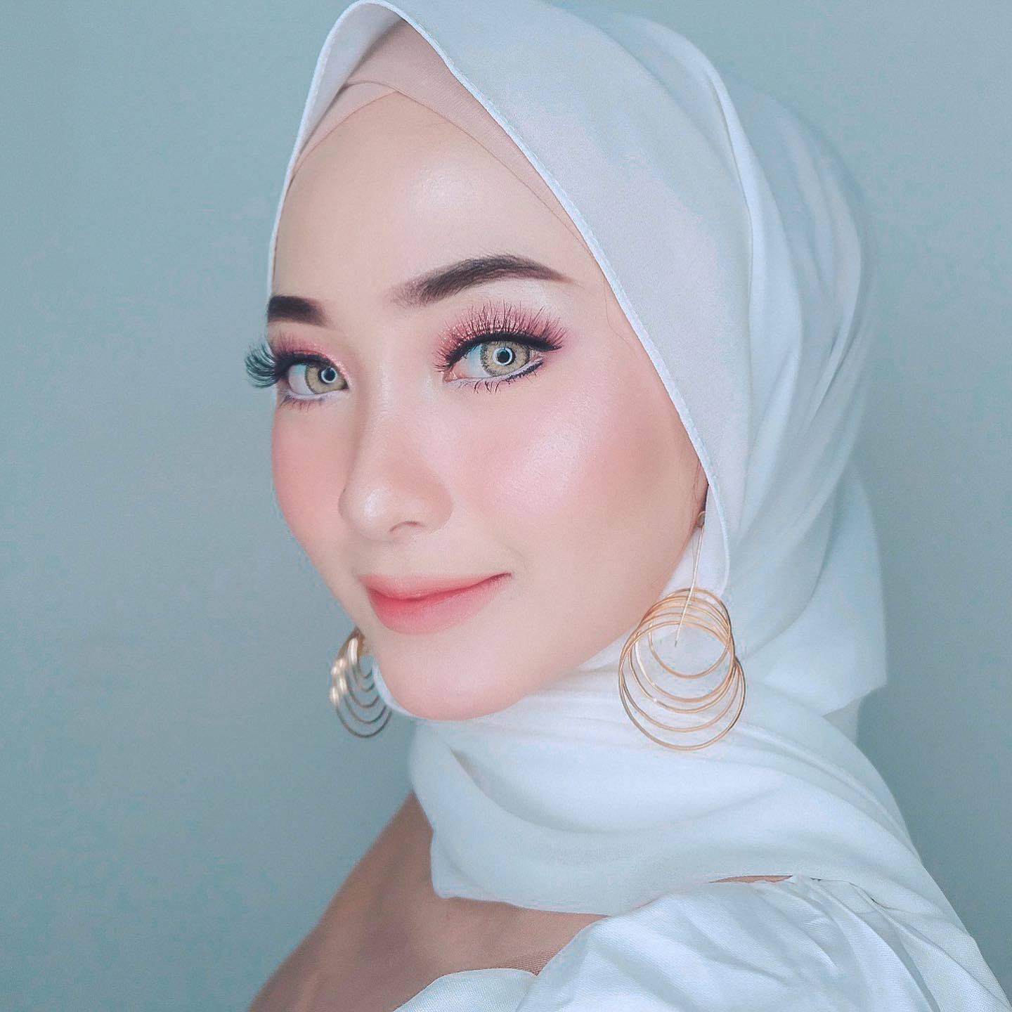 Wanita Indonesia mengenakan hijab warna putih dan anting gold