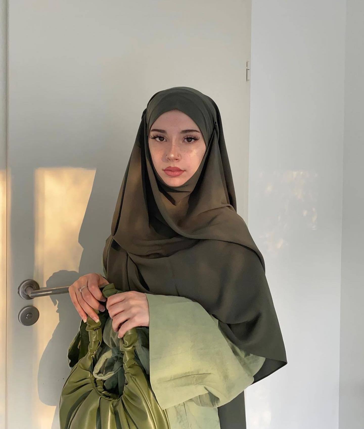 Wanita Kaukasia mengenakan hijab syar'i panjang warna hijau army.