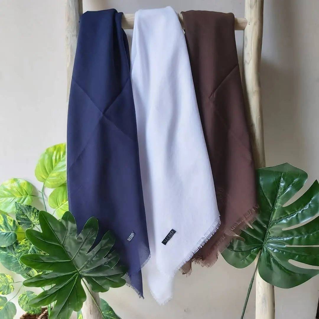 Kerudung segi empat bahan katun saudia beragam warna yang digantung rapi.