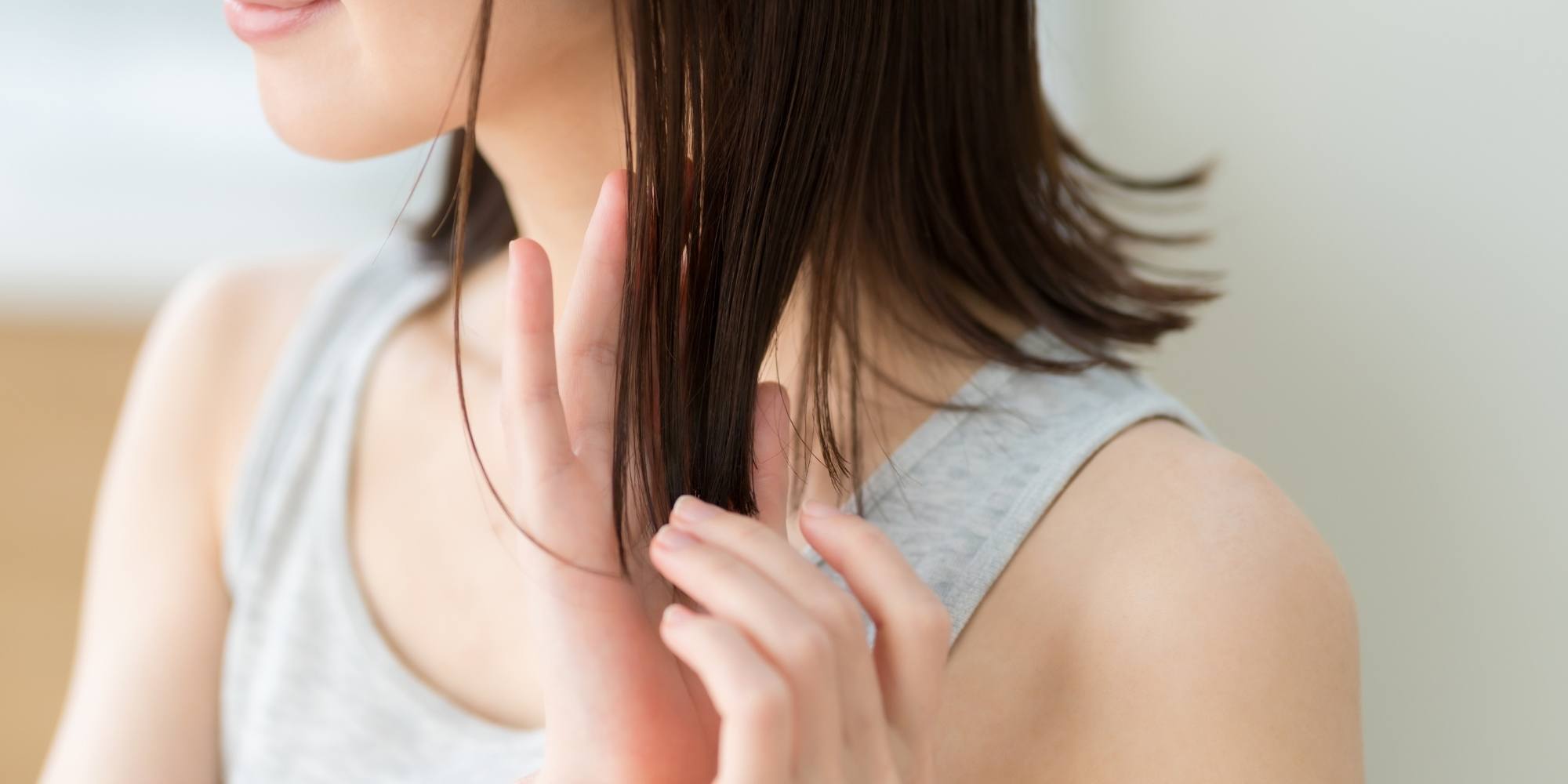 wanita dengan rambut sebahu sedang menggunakan lidah buaya pada rambut
