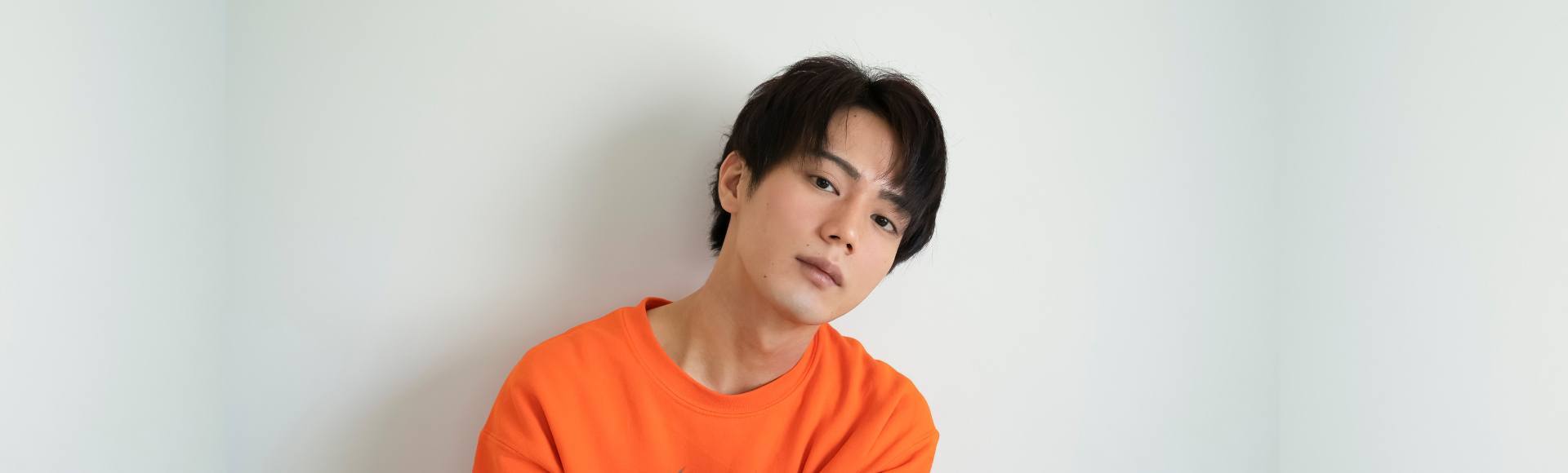 Pria Asia dengan potongan rambut pendek berponi belah tengah.