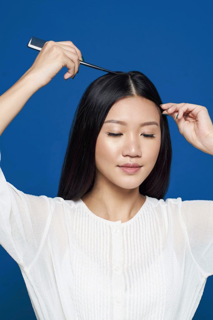Crown braid - Wanita asia dengan baju putih membelah rambut panjangnya di tengah.