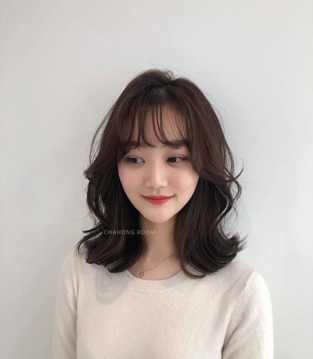 Wanita Asia dengan rambut sebahu dan poni