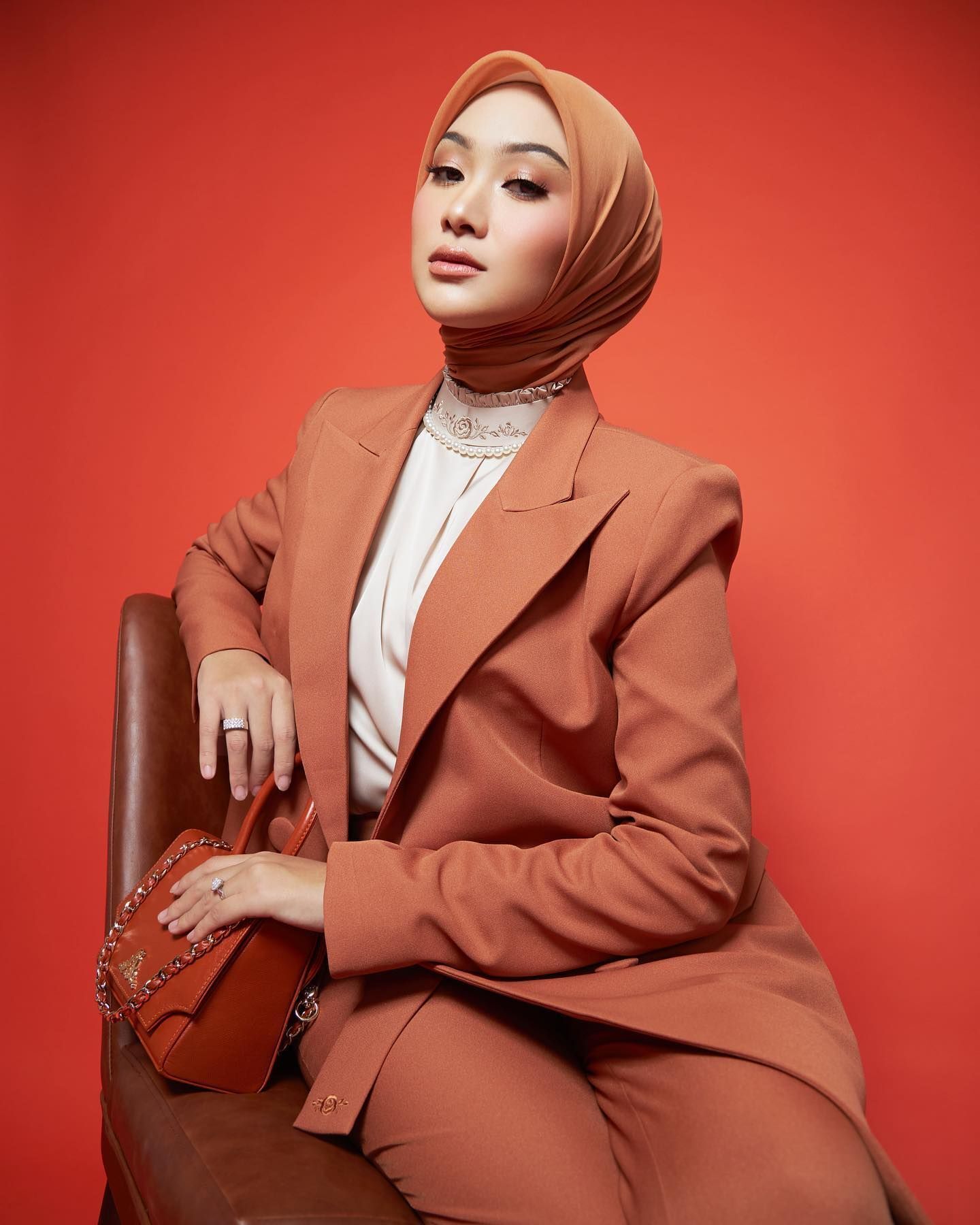 Wanita Indonesia bergaya elegan dan formal mengenakan model hijab sleek dan rapi.