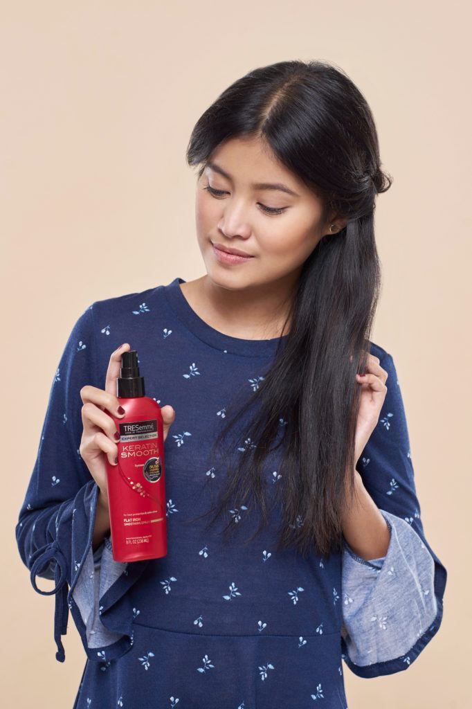 Wanita asia dengan rambut hitam menyemprotkan TRESemme Heat Protection Spray - half crown braid