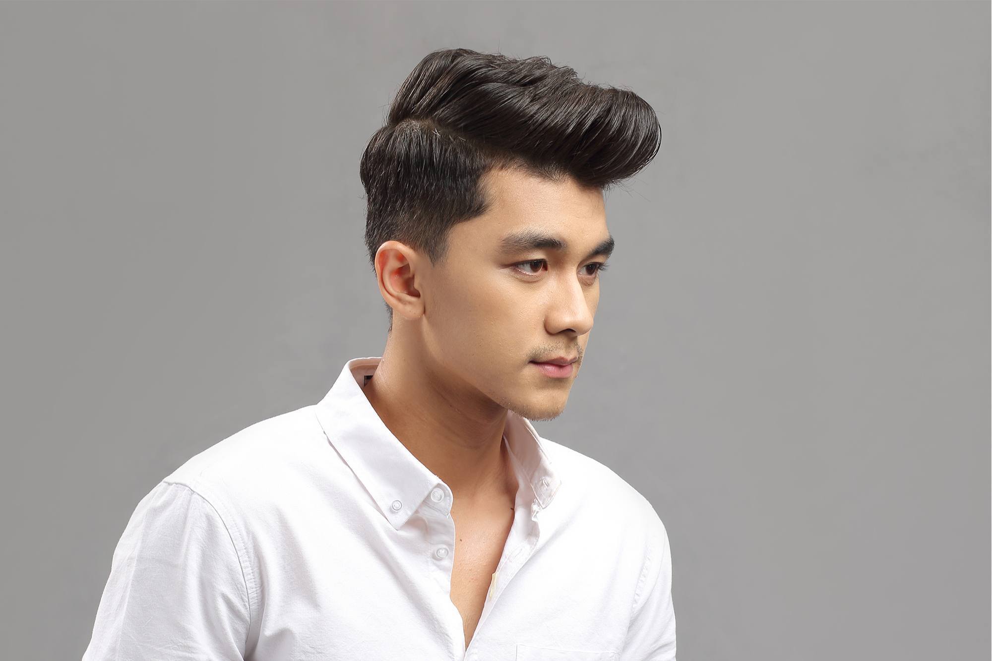 pria asia dengan kemeja putih dan gaya rambut pompadour klasik