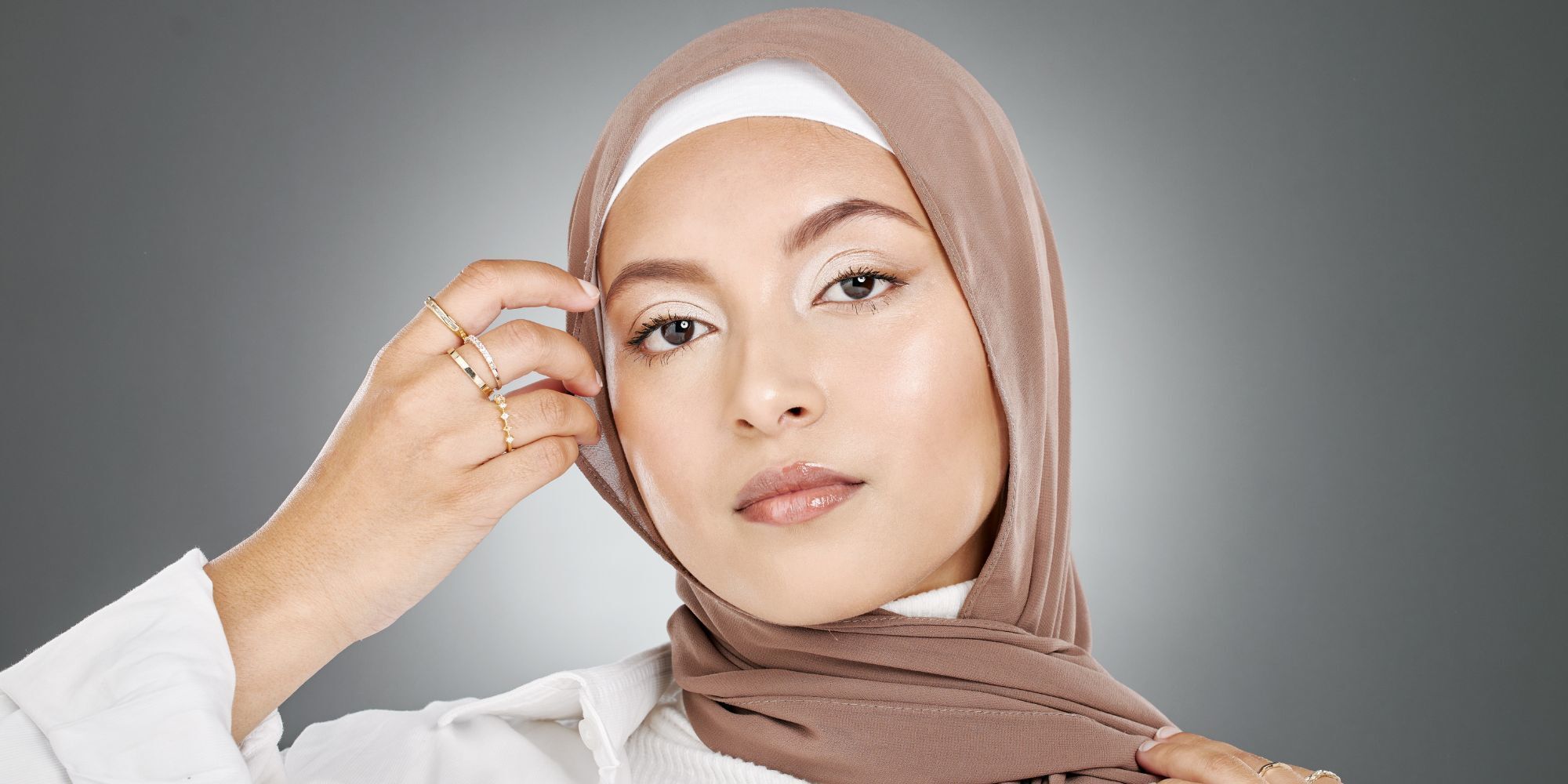 Wanita Asia/Arab dengan pashmina warna cokelat nude.