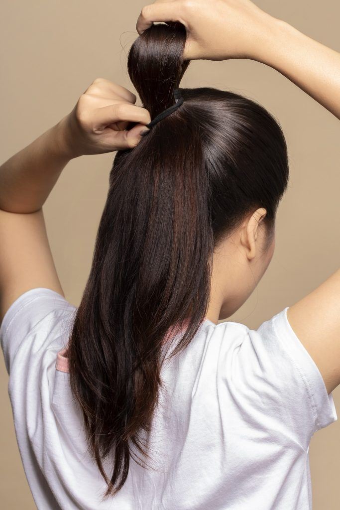 wanita asia sedang membuat lubang pada messy fan bun