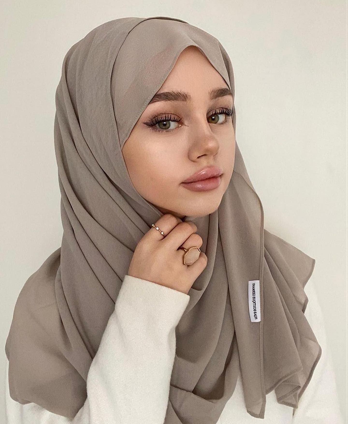 Wanita kaukasia kenakan pashmina sifon ceruti warna abu-abu.