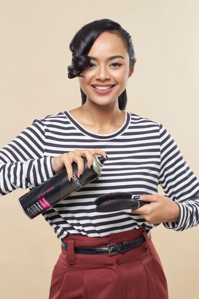 Wanita asia dengan rambut hitam menyisir poni membentuk gaya pin up hair.