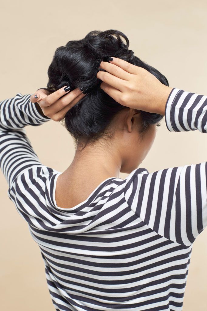 Wanita asia dengan rambut hitam membentuk messy bun gaya rambut pin up hair