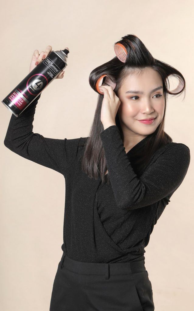 wanita asia dengan rambut lurus dan rol rambut serta hairspray