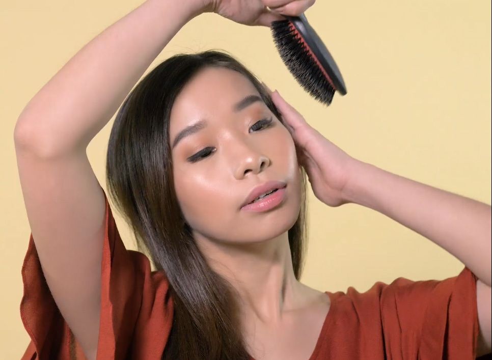 Wanita Asia menyisir rambutnya.