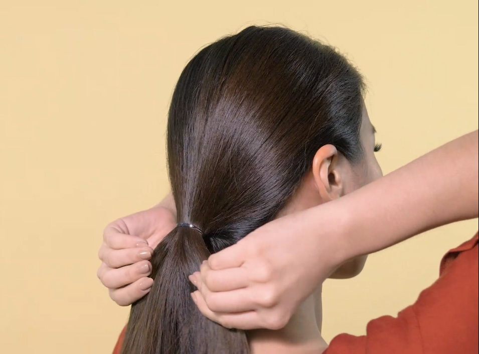 Wanita Asia mengikat rambut.