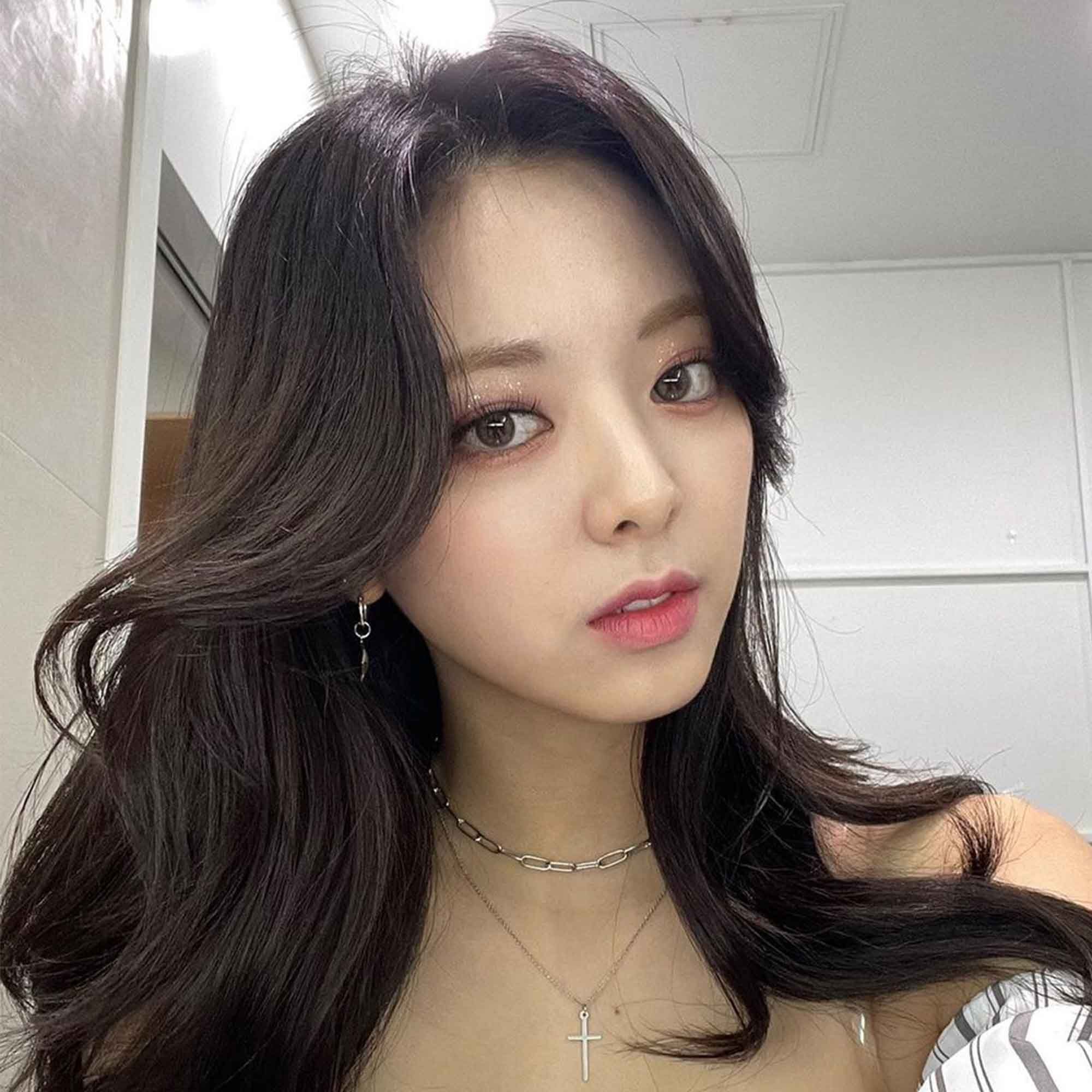 yuna dari itzy dengan rambut hitam panjang dan poni curtainbangs