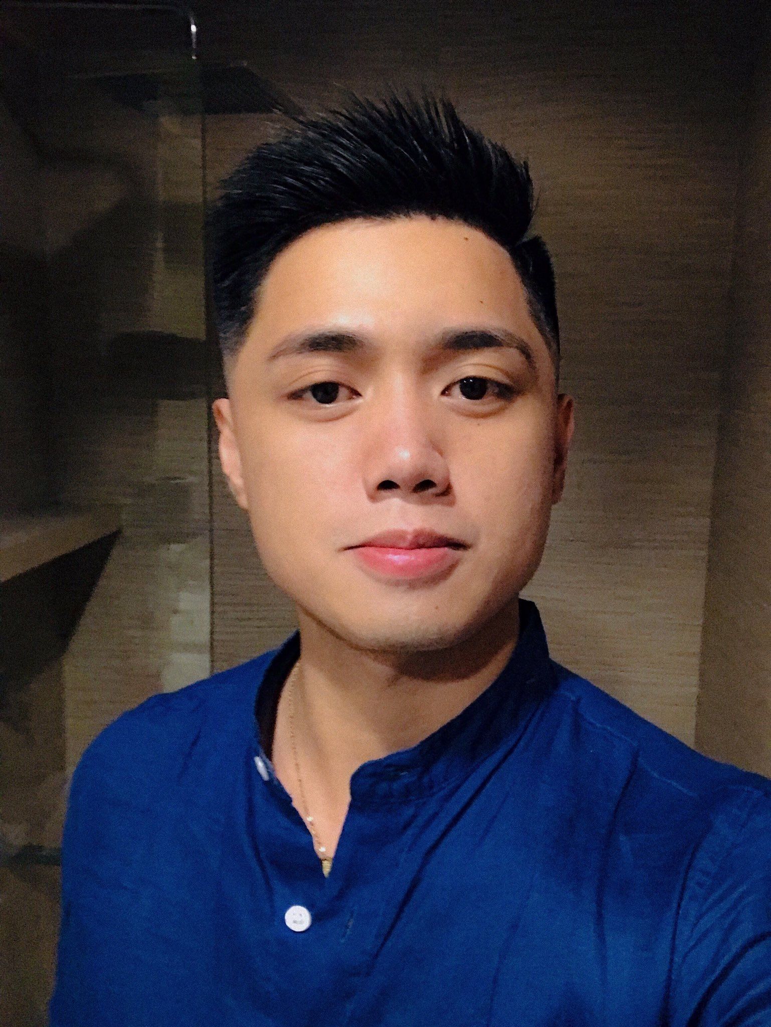 Pria Asia dengan gaya rambut spike dengan cukuran fade di bagian samping.