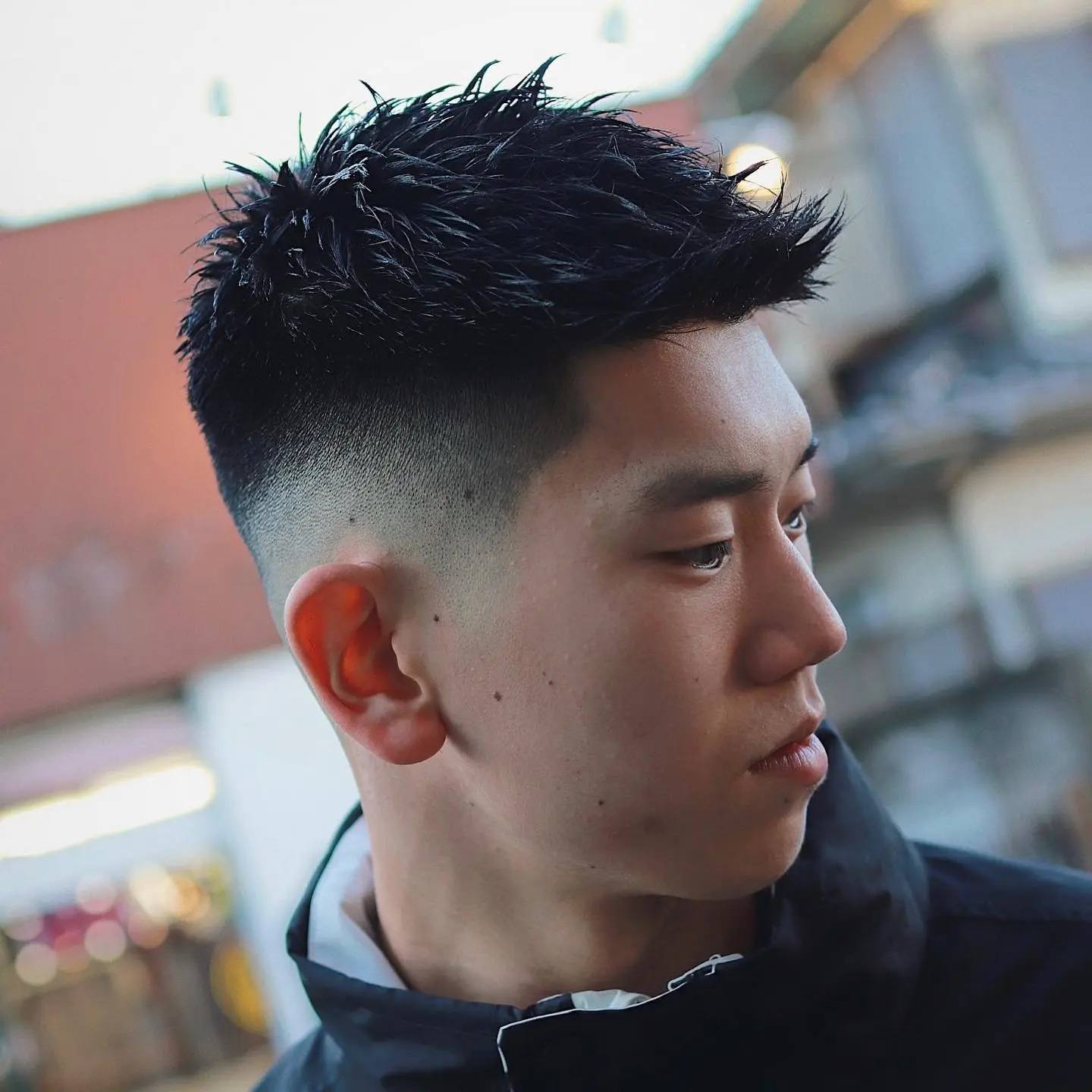 Pria Asia dengan potongan rambut spike di bagian atas dan tipis di bagian samping.