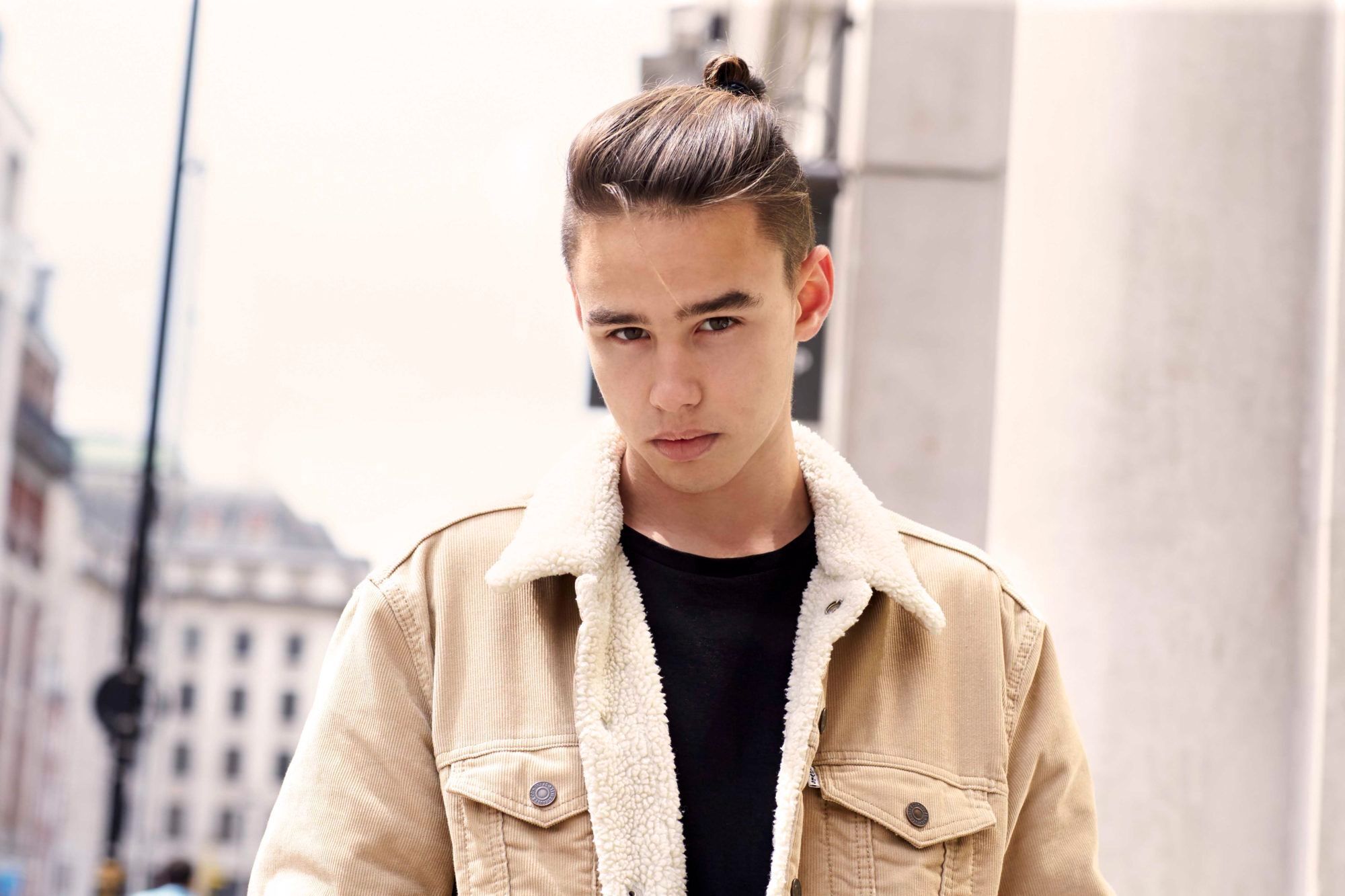 Pria Asia dengan rambut undercut man bun.