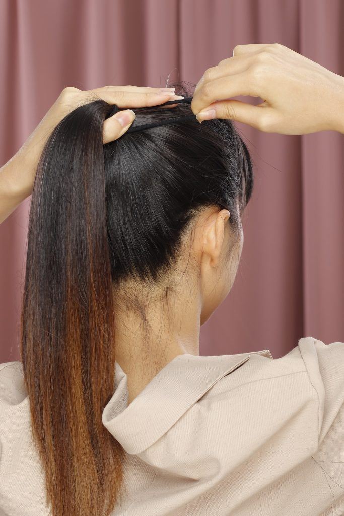 Wanita Asia sedang mengikat rambut