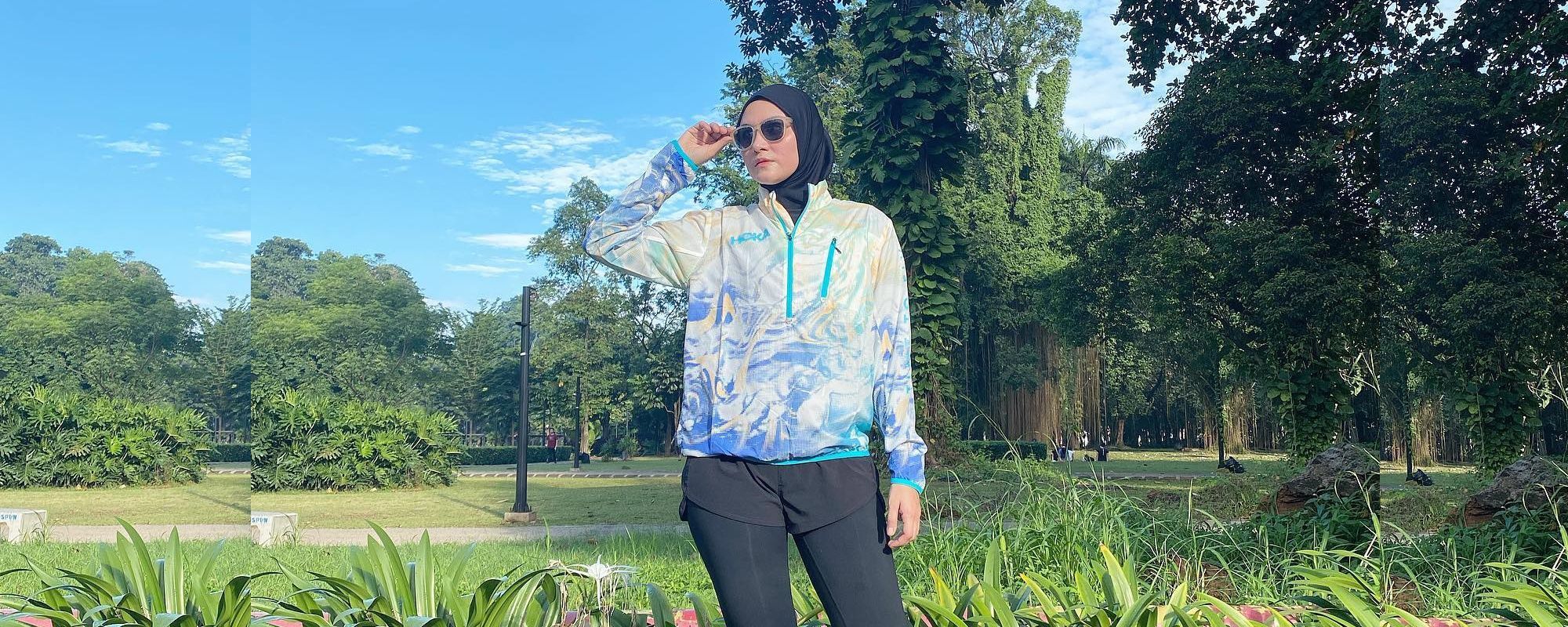 Aktris Zee Zee Shahab tampil mengenakan baju olahraga dengan jaket parasut, celana pendek dan lengging hitam.