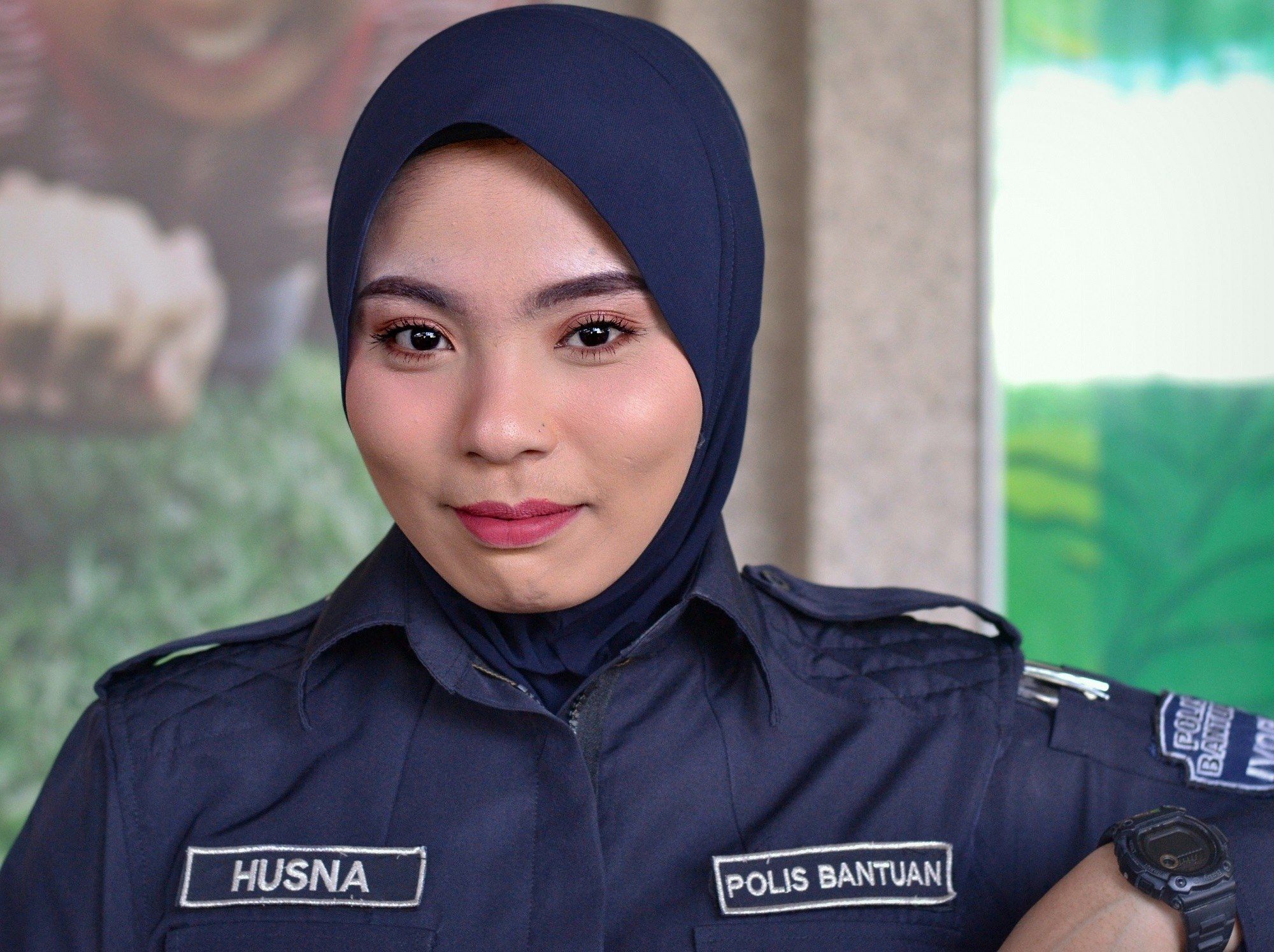 Polisi wanita Malaysia dengan gaya hijab instan warna biru navy.