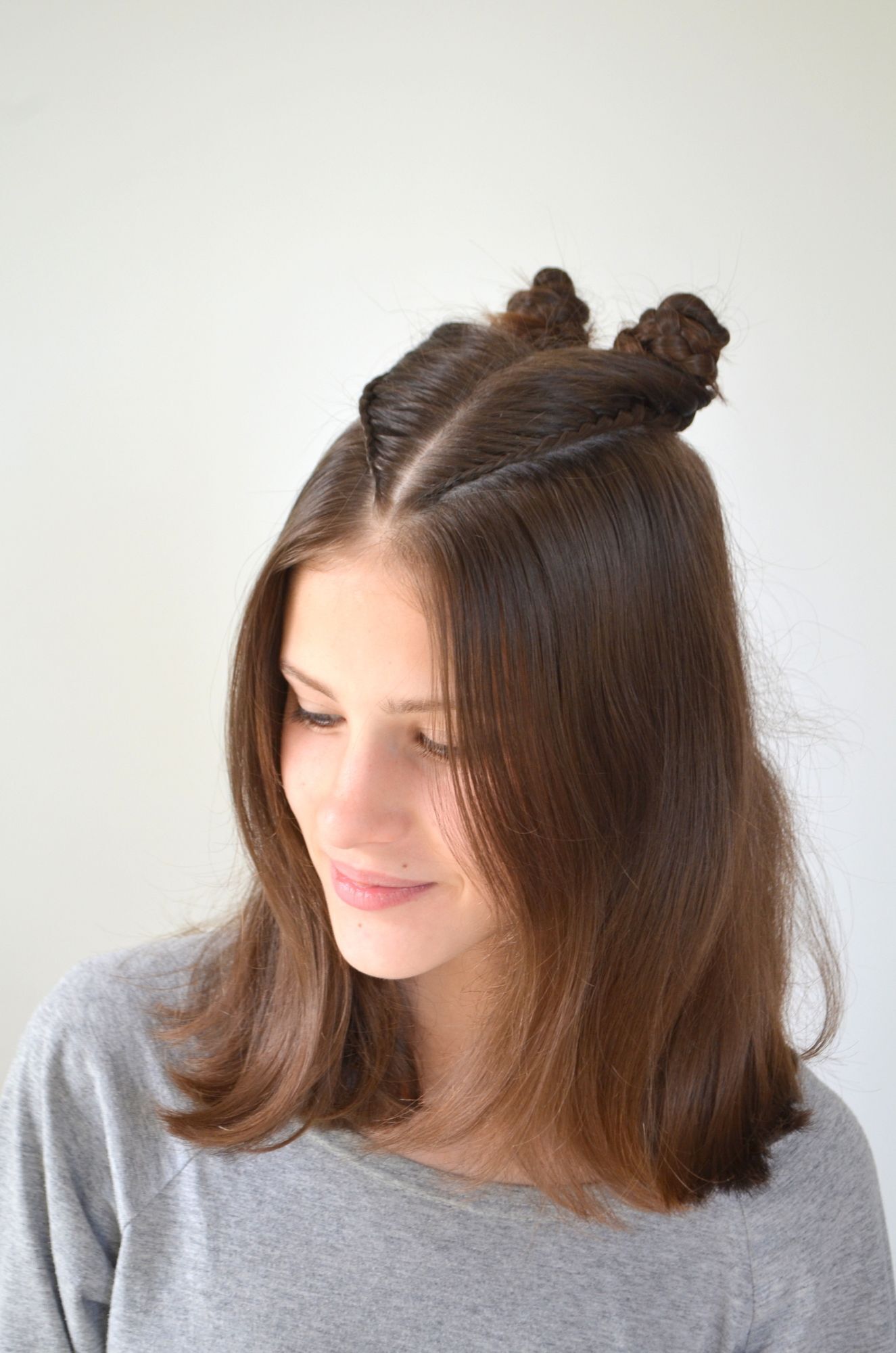Gaya rambut double buns bisa divariasikan dengan gaya kepang. (Foto: Shutterstock)