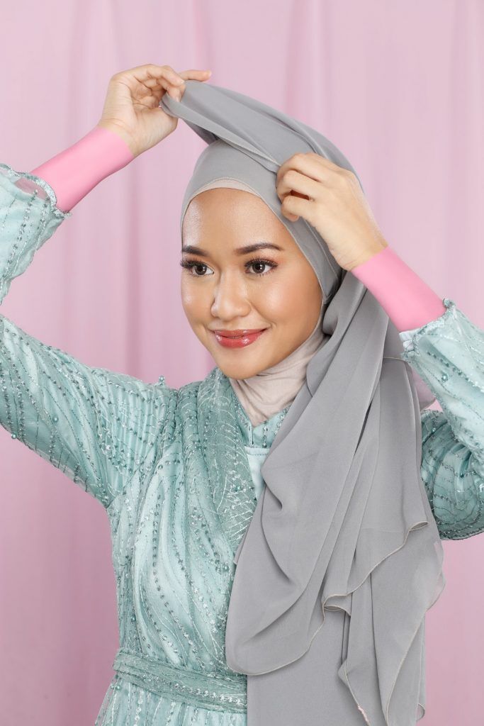 Wanita Asia memasangkan hijab sifon di kepalanya