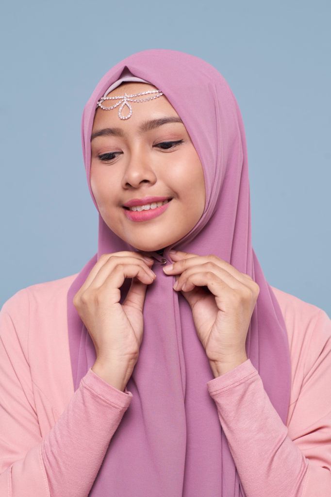 Wanita asia menggunakan peniti di bawah dagu.