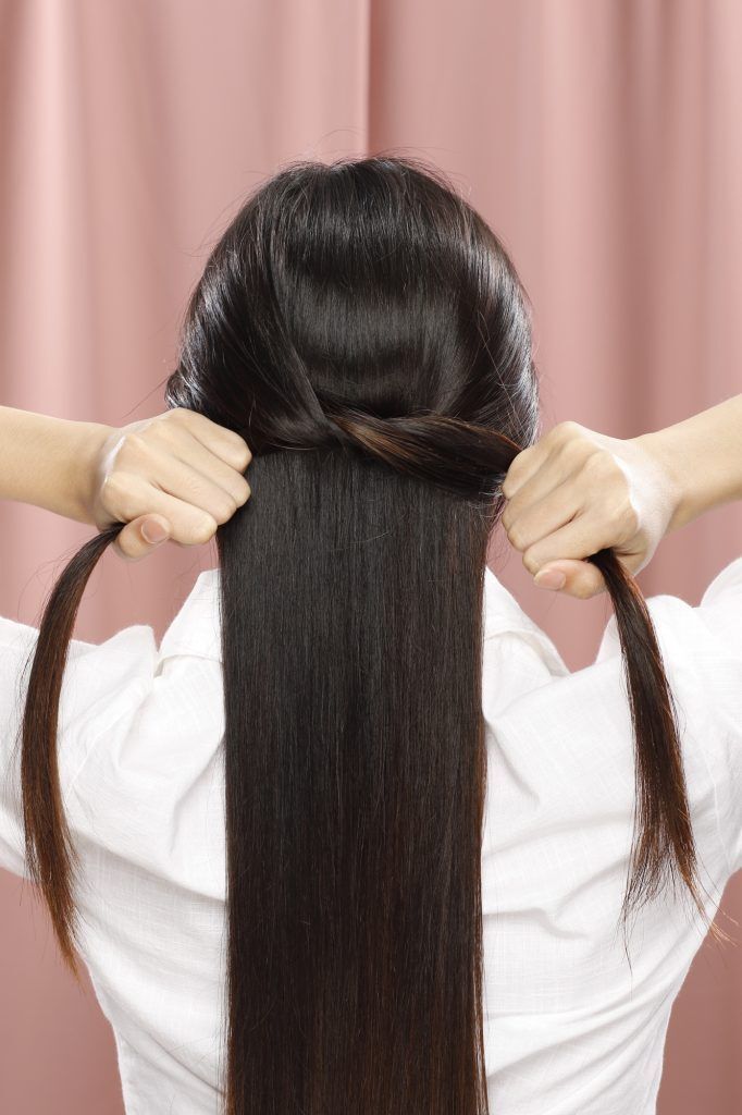 wanita asia sedang menata rambut panjang