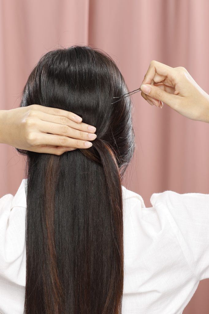 wanita asia sedang menata rambut panjang