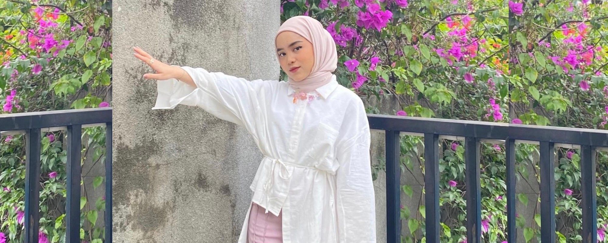 Wanita Indonesia memakai hijab instan warna nude dengan kemeja putih berpotongan asimetris.
