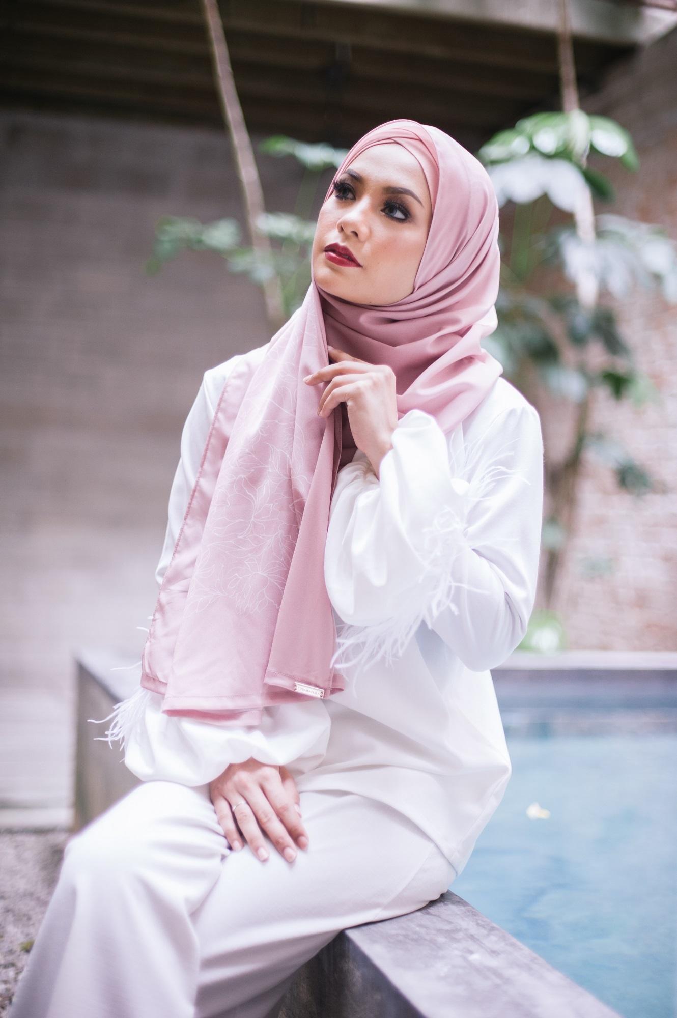 Wanita Asia memakai hijab pashmina berwarna pink