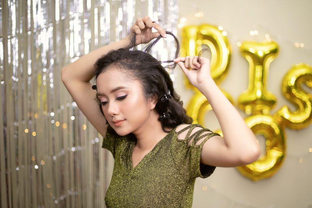 Wanita asia dengan rambut hitam keriting mengepang rambut.