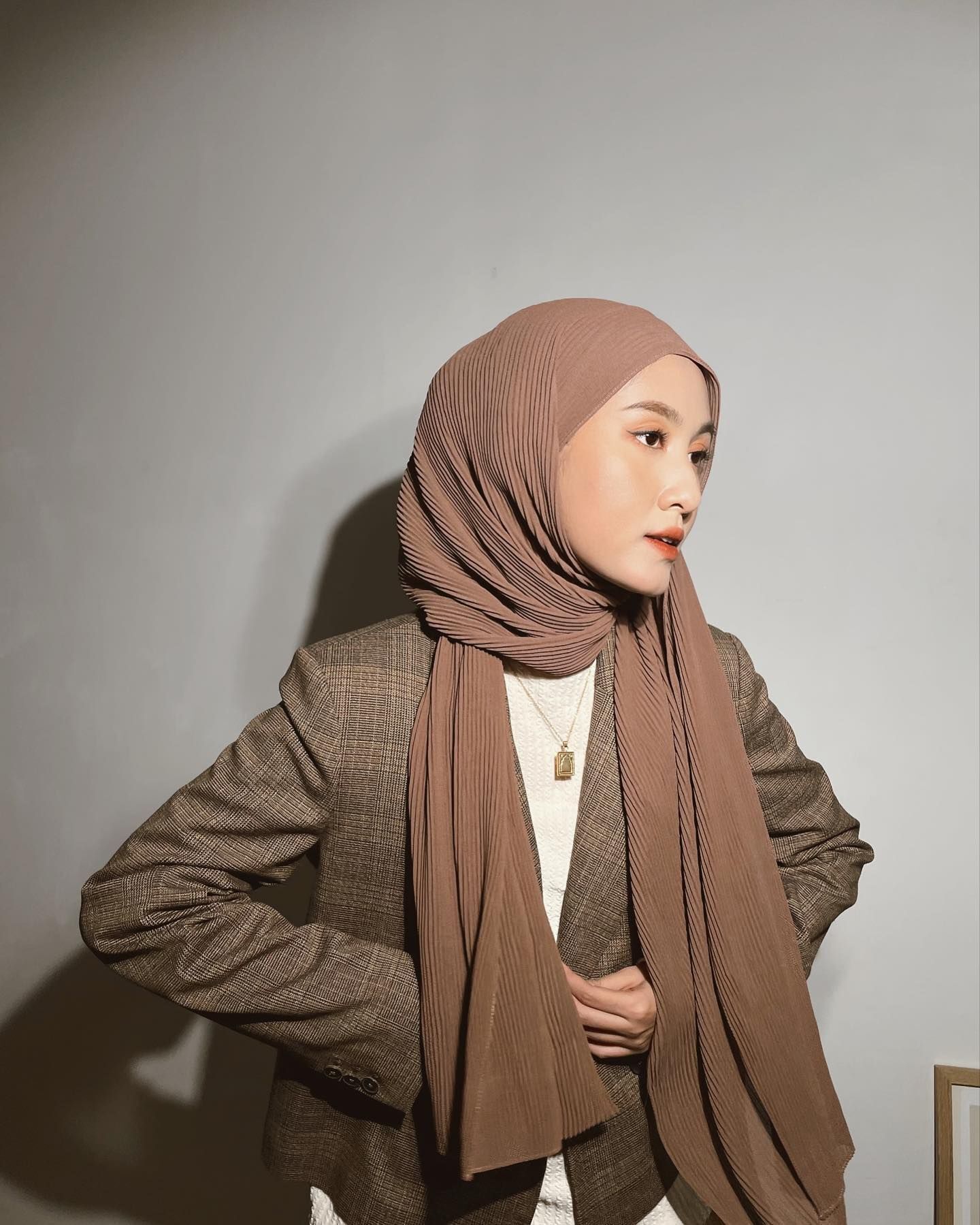 Wanita Indonesia mengenakan hijab pashmina berbahan pleats atau plisket