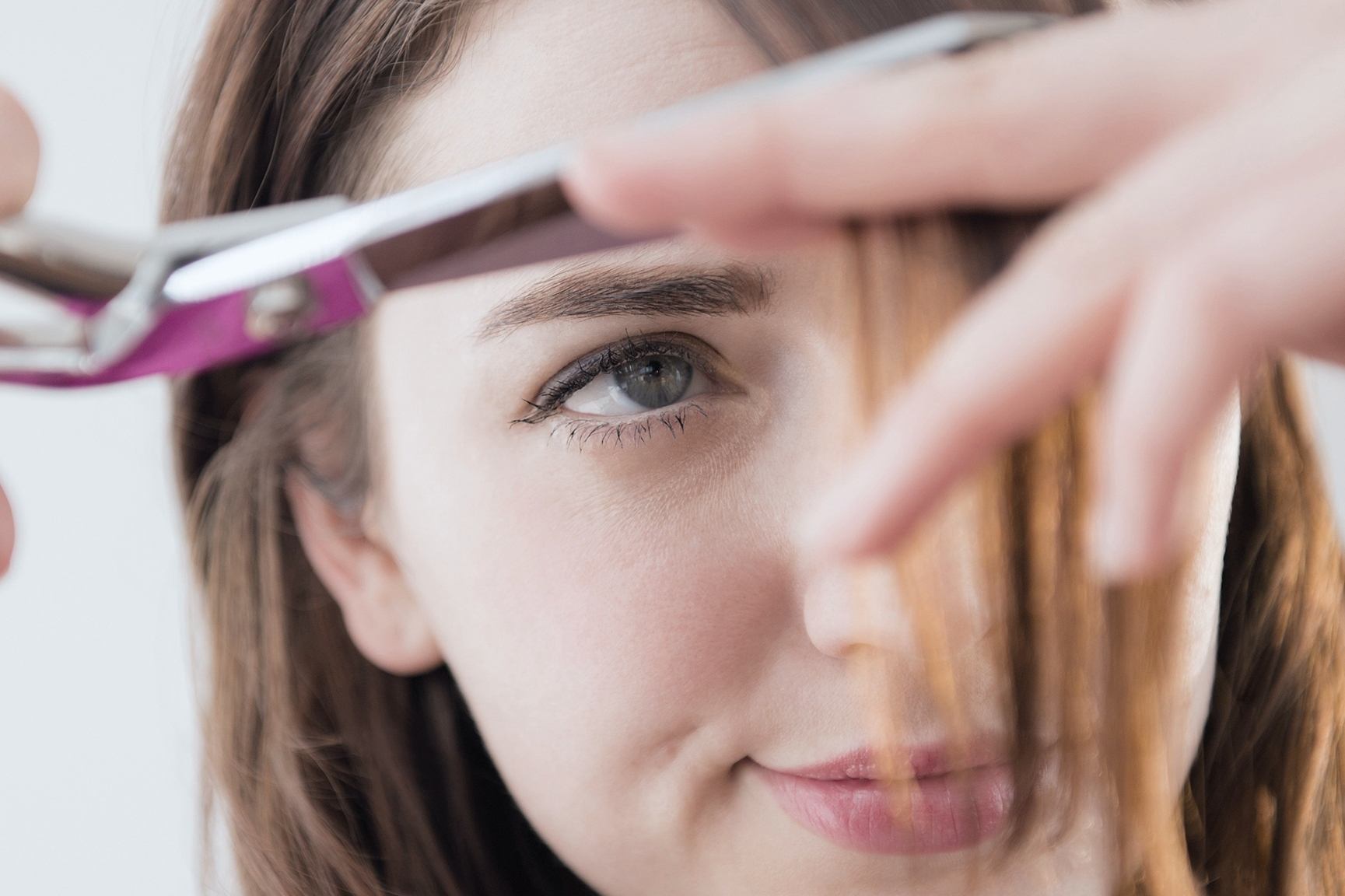 wanita sedang menggunting poni sendiri