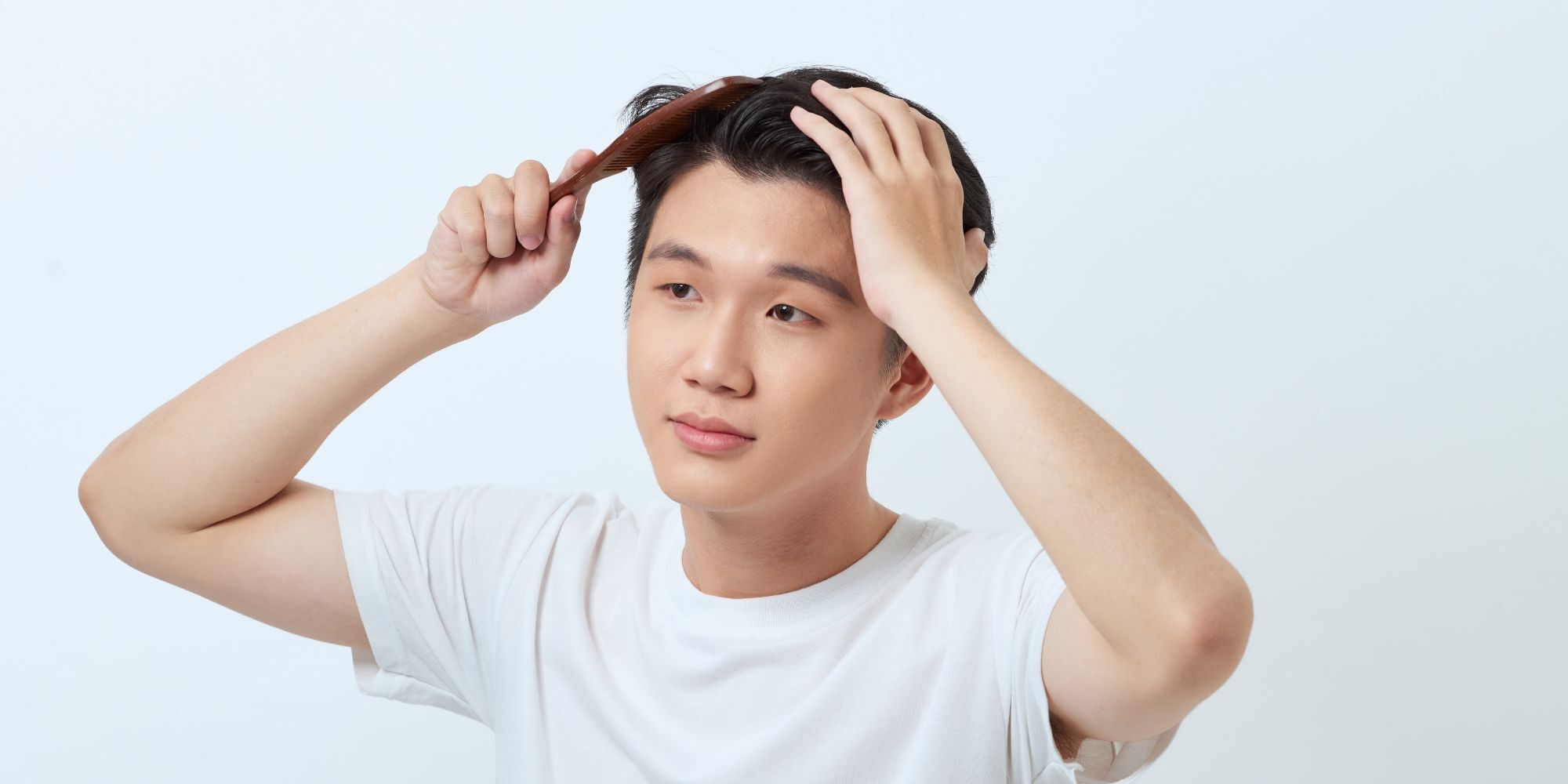 pria sedang menyisir rambutnya yang kaku