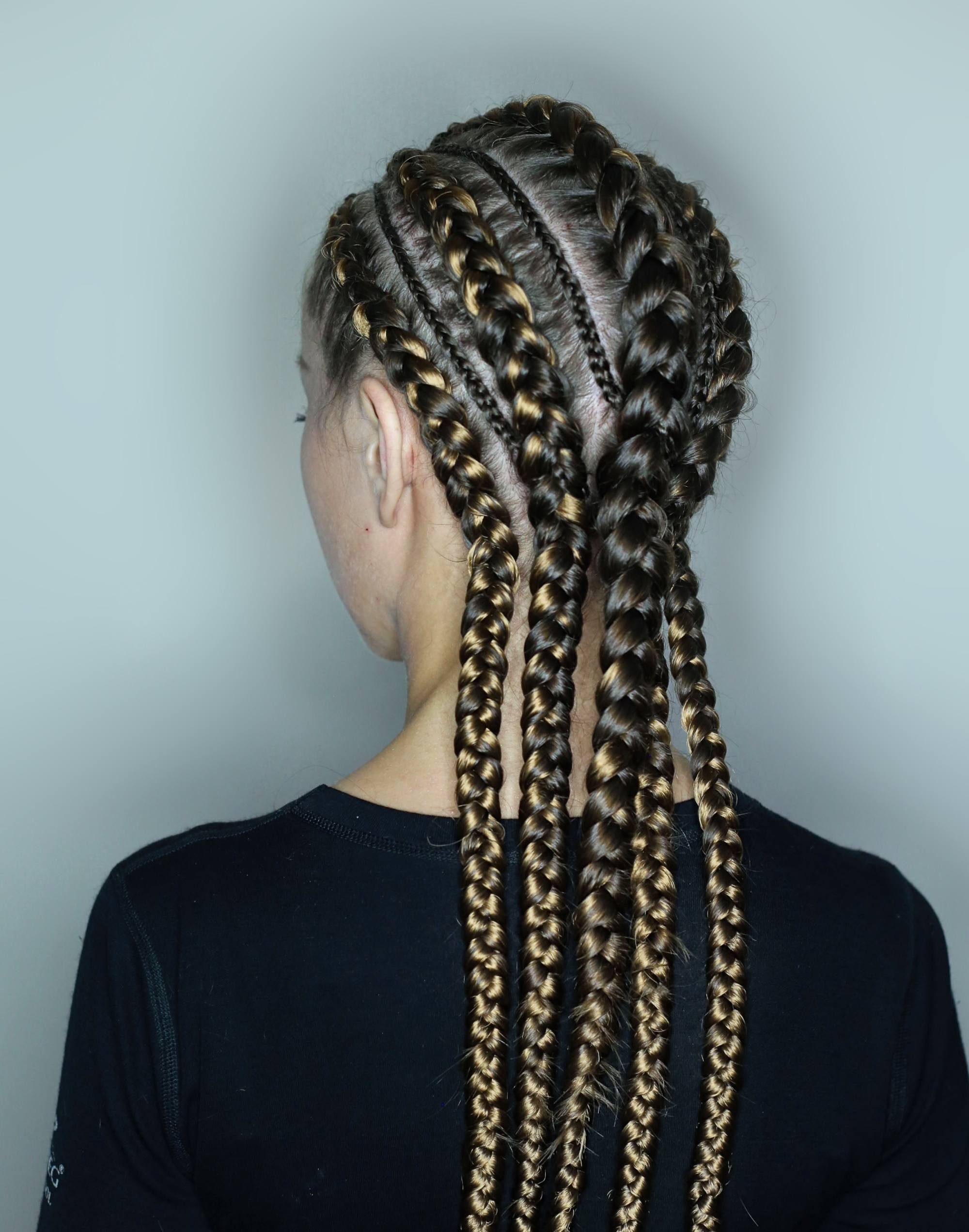 Gaya rambut cornrow wanita dengan variasi kepangan besar-besar dan kecil-kecil.