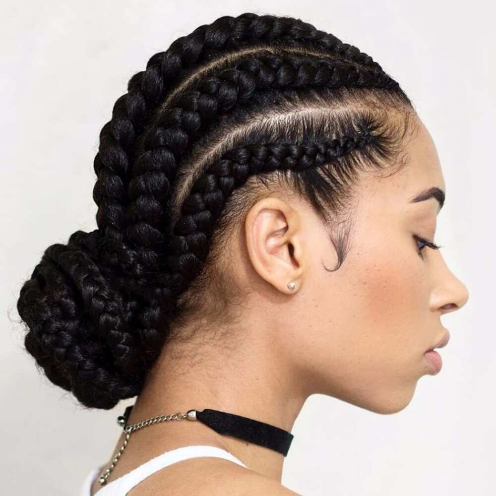 Rambut wanita dengan gaya kepang cornrow yang ditata dengan cepol bawah atau low bun.