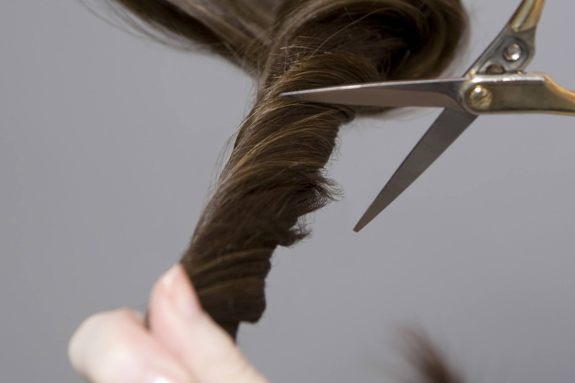 wanita sedang menggunting rambut sendiri