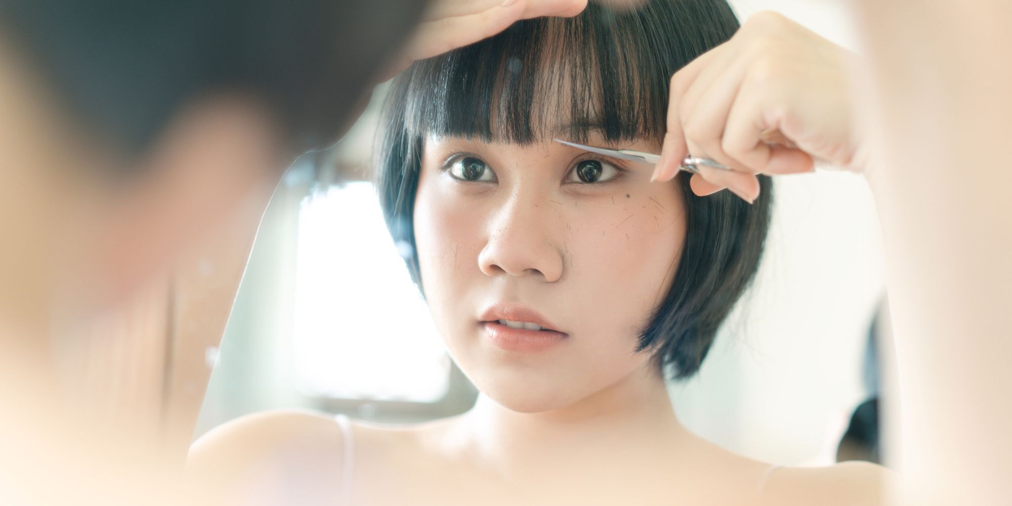 wanita asia memegang gunting potong poni rambut