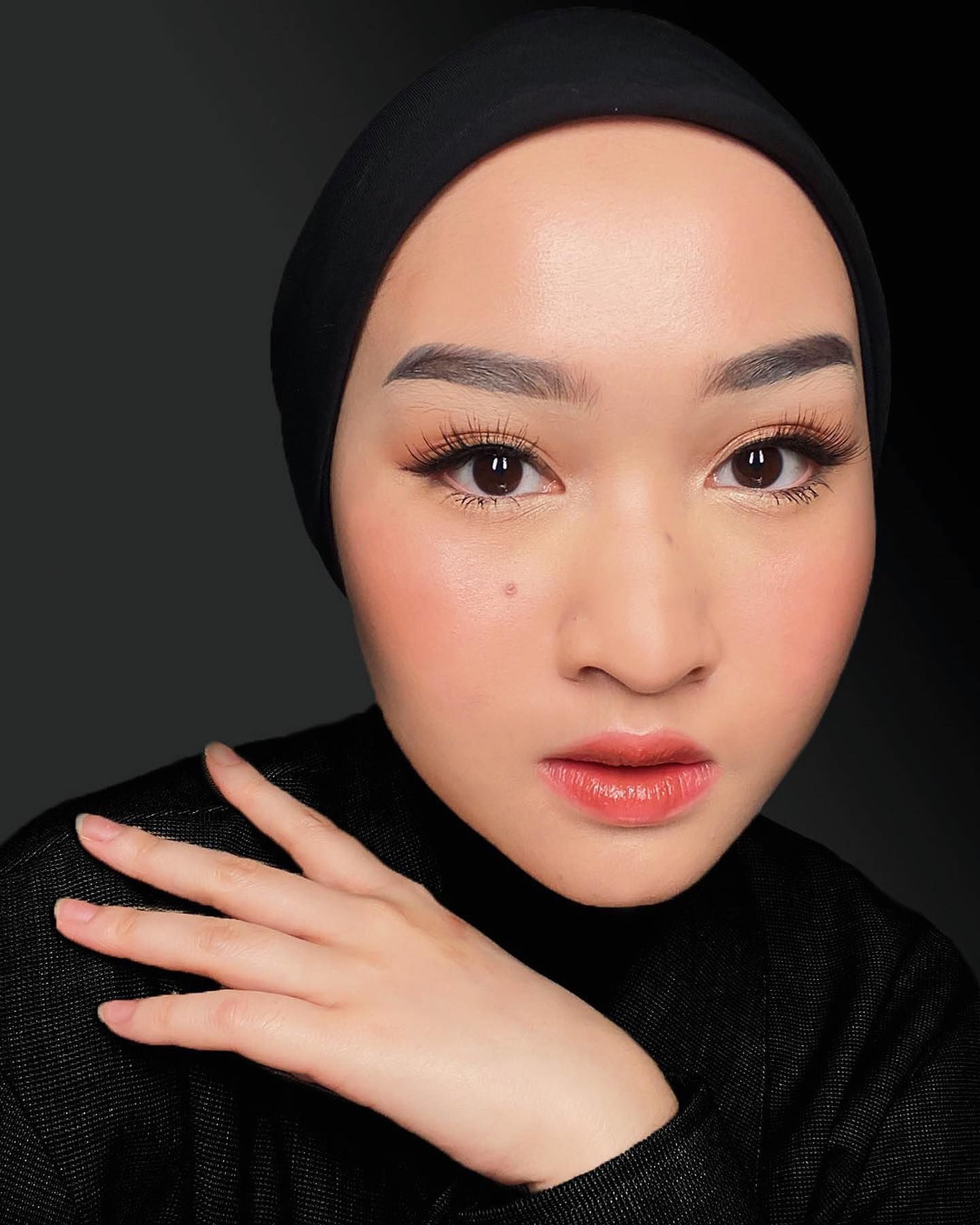 Wanita Asia mengenakan hijab warna hitam dengan sentuhan make up a la Korea