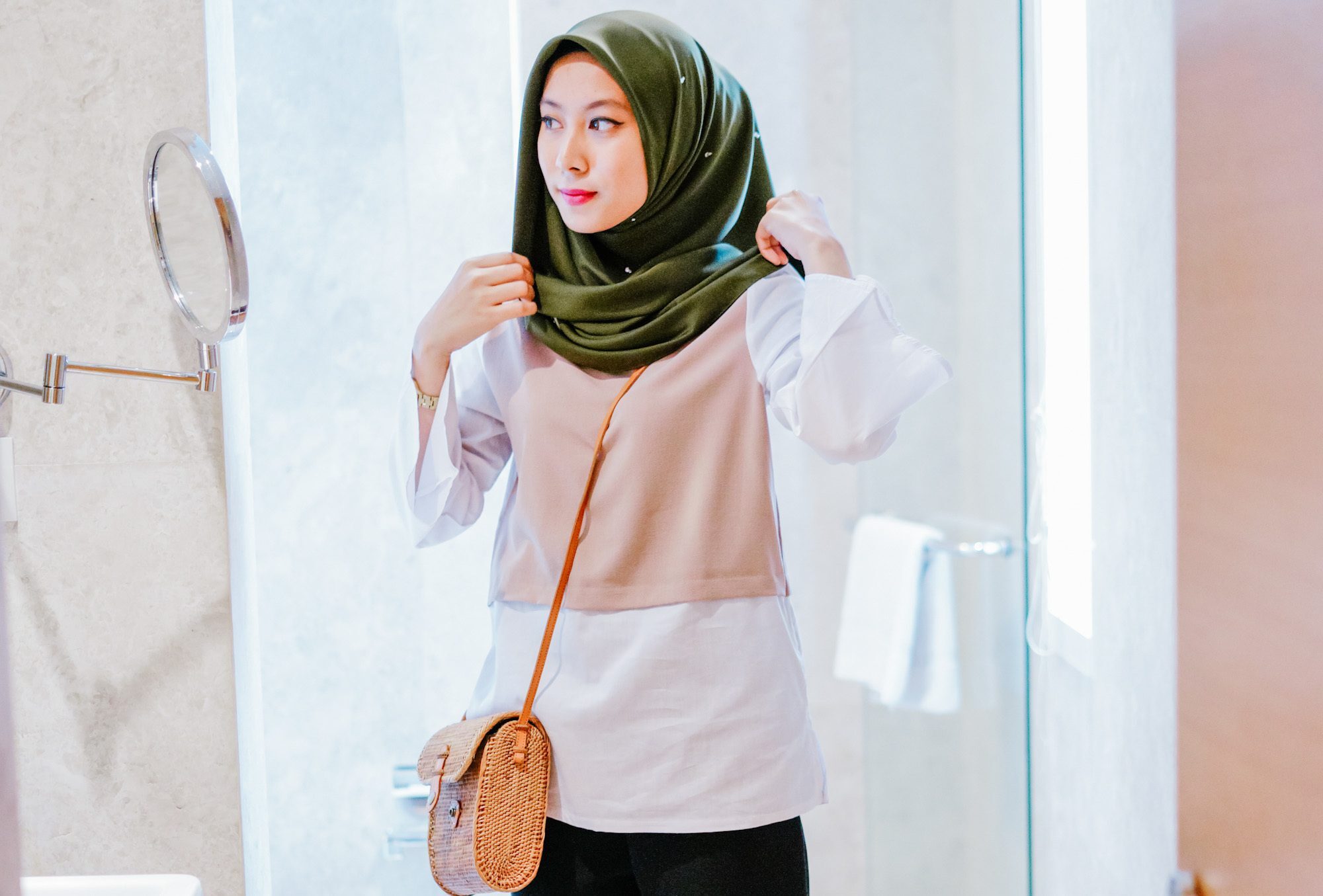 Wanita Asia memakai hijab segi empat layer berwarna hijau.