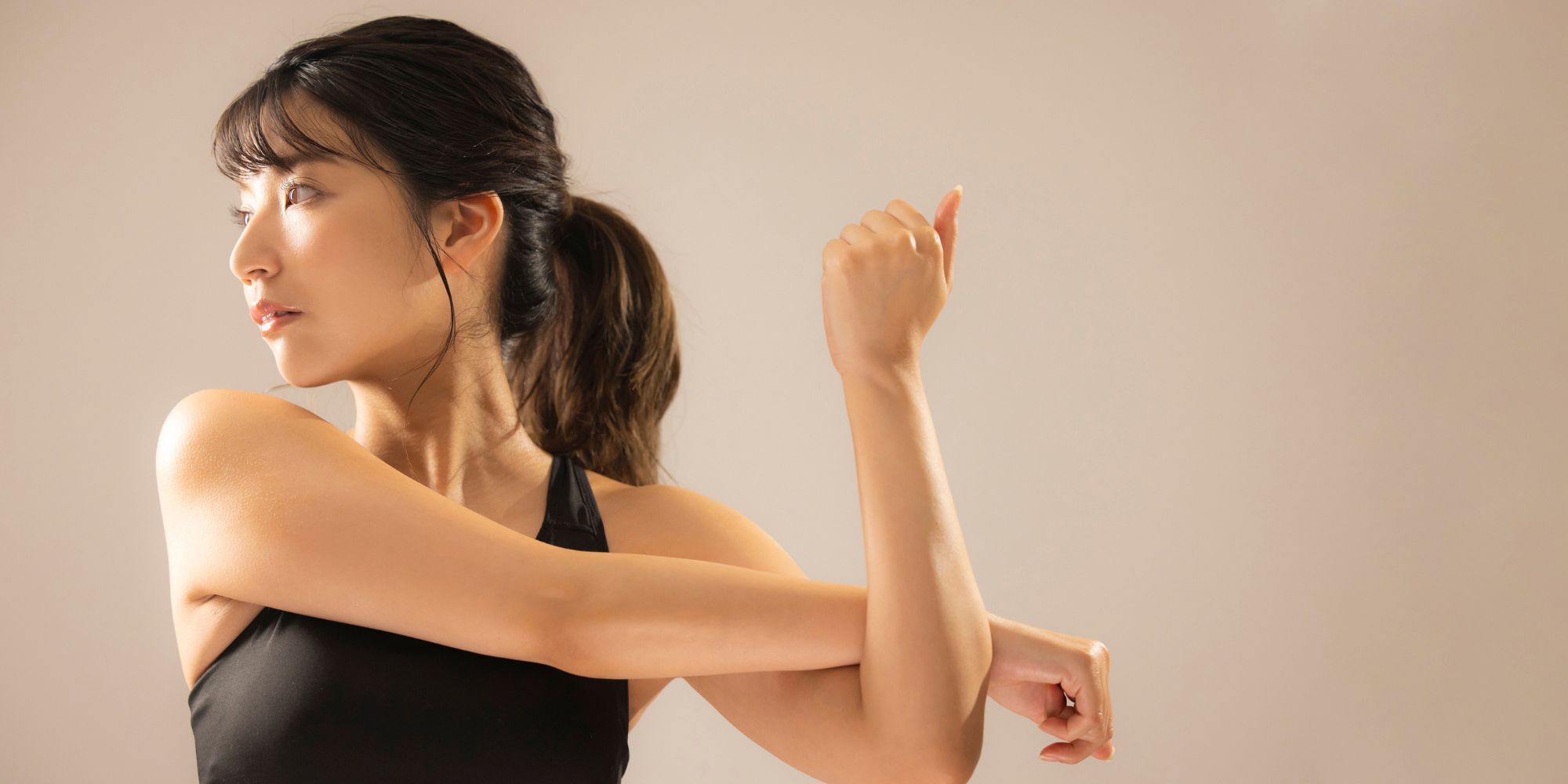 Wanita asia dengan rambut yang diikat sedang berolahraga