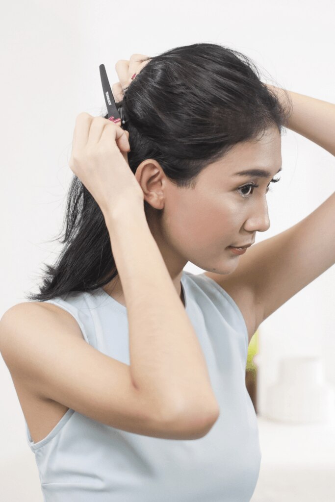 wanita asia sedang menata dan membagi rambut