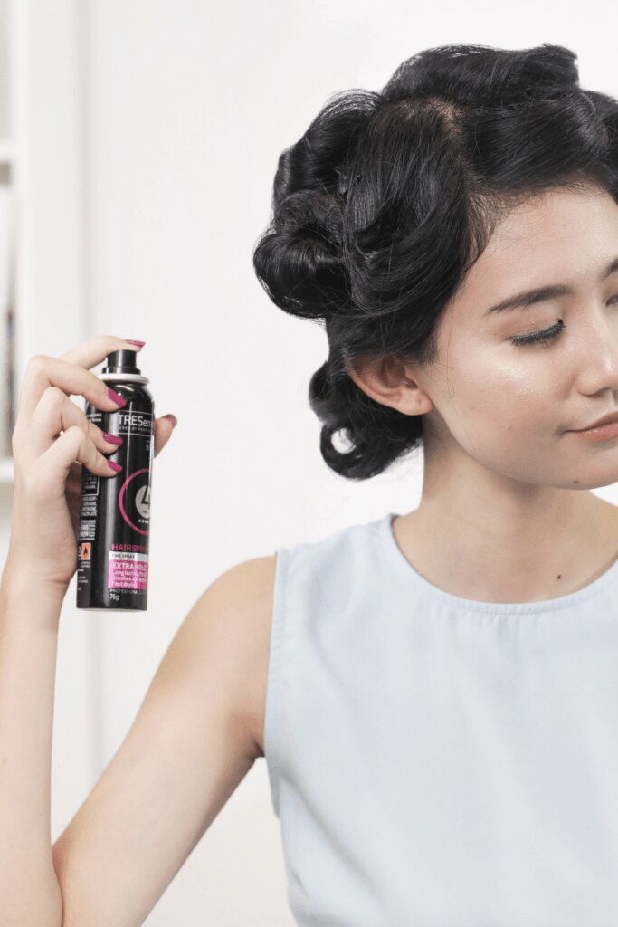 wanita asia menyemprotkan hairspray