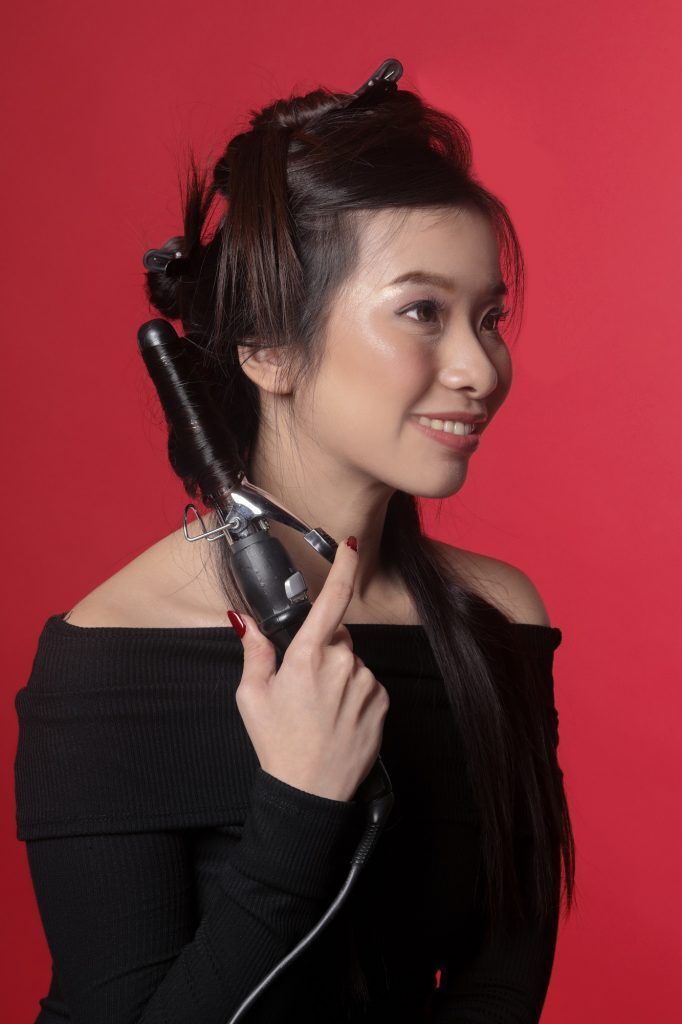 Wanita sedang curling rambut