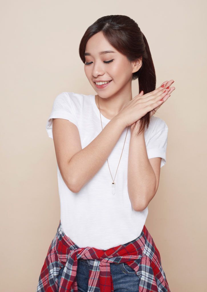 Wanita Asia dengan rambut ponytail sedang memakai vitamin rambut