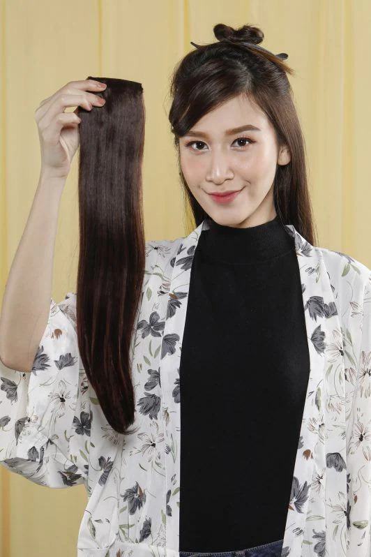 wanita asia sedang memegang hair clip extensions