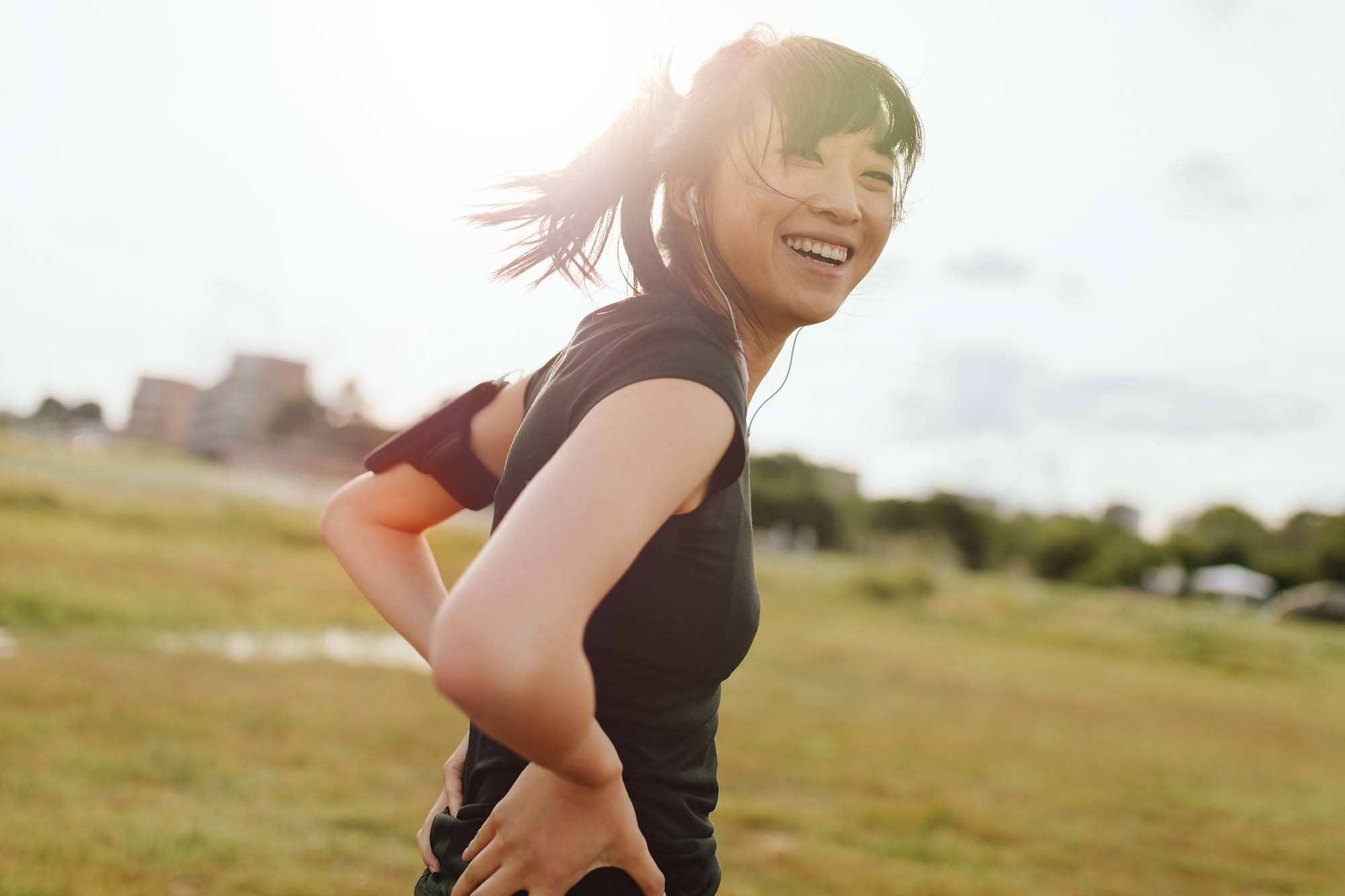 wanita asia sedang berolahraga di luar rumah di bawah paparan sinar matahari